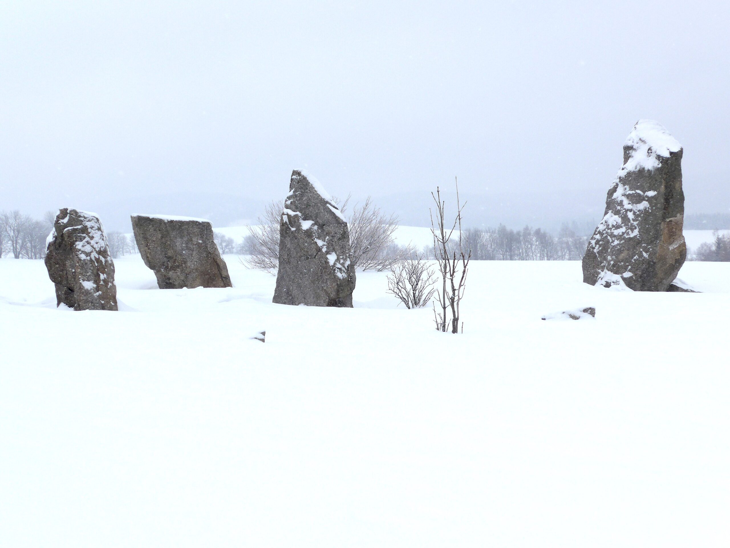 Tekst alternatywny (ALT): Ośnieżone menhiry tworzące kamienny krąg Stonehenge w Říčkach v Orlických horách w Czechach.